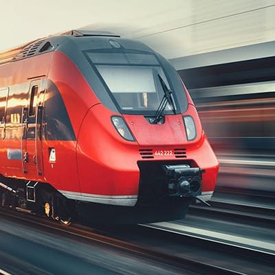 Beautiful railway station with modern high speed red commuter train with motion blur effect at colorful sunset in Nuremberg, Germany. Railroad with vintage toning